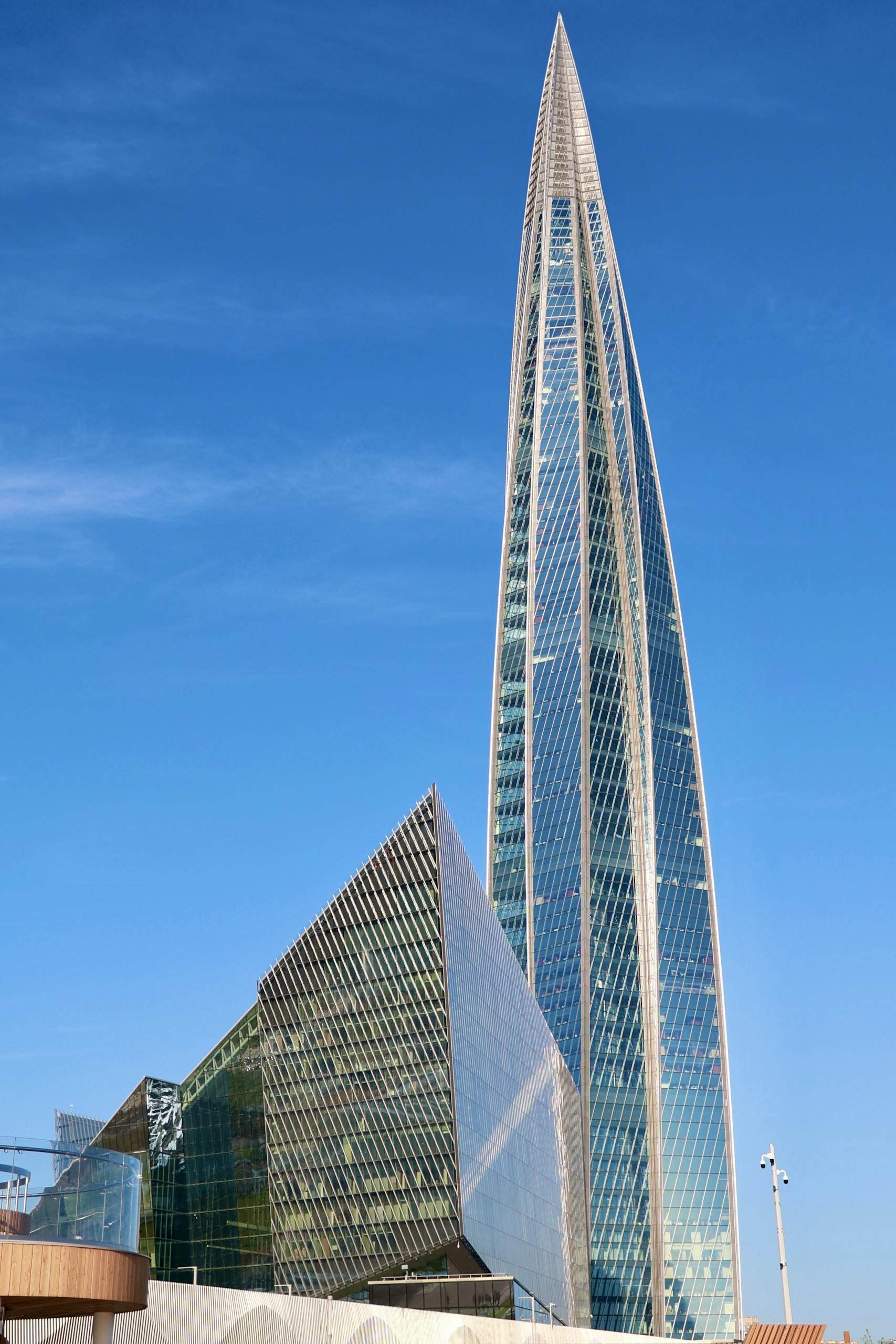A striking modern skyscraper with sleek glass design reaching into a clear blue sky.